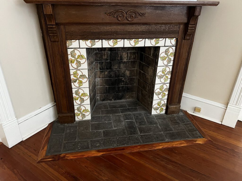 An ornate tiled fireplace inside the Artist Cottage