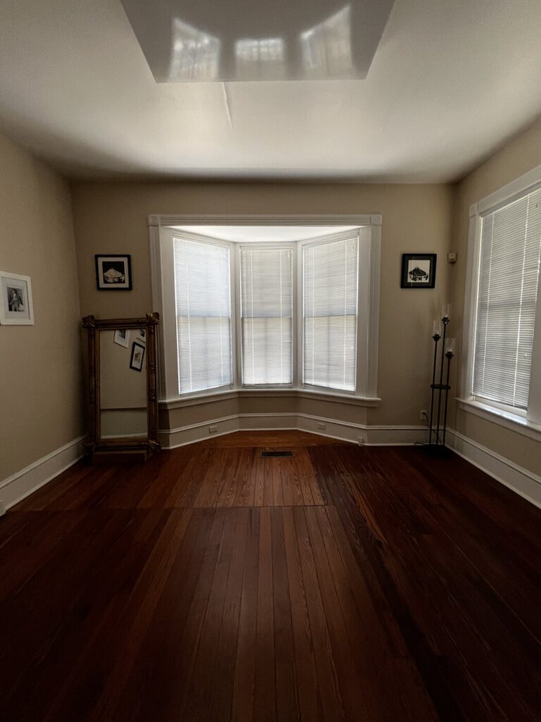 A bright bay-window room in the Artist Cottage